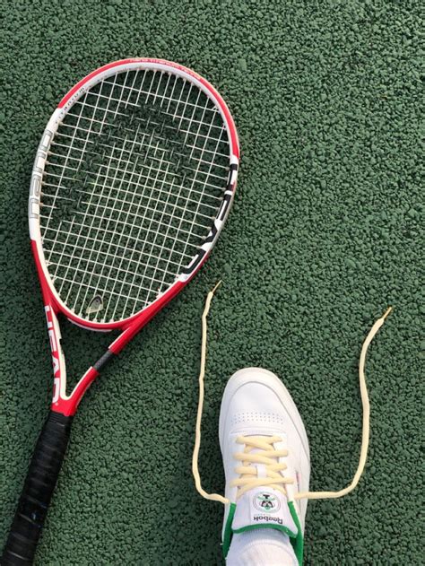 A Tennis Racket And Shoe On The Ground