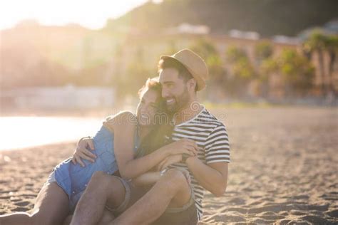 Happy Couple Sitting Together On Beach Cuddling Stock Image Image Of