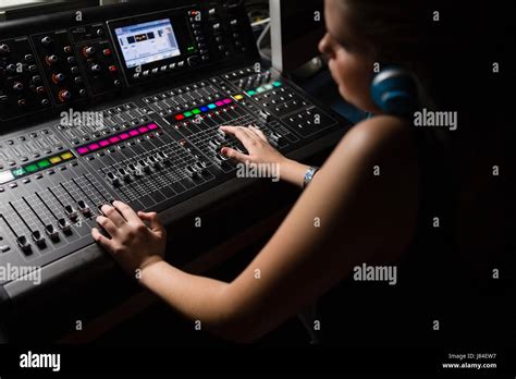 Female Audio Engineer Using Sound Mixer In Recording Studio Stock Photo