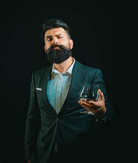 Premium Photo Man Or Businessman Drinks Cognac On Black Background