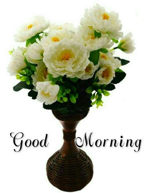 A Vase Filled With White Flowers Sitting On Top Of A Wooden Table Next