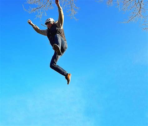 Premium Photo Low Angle View Of Man Jumping Against Clear Blue Sky