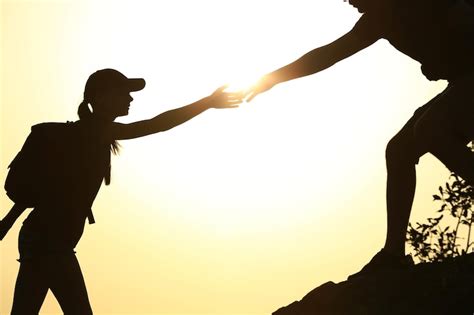 Premium Photo Silhouettes Of Man And Woman Helping Each Other To Climb On Hill Against Sunset