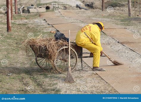 A Sewage Cleaner Is Loading The Garbage Collecting Cart To Keep The