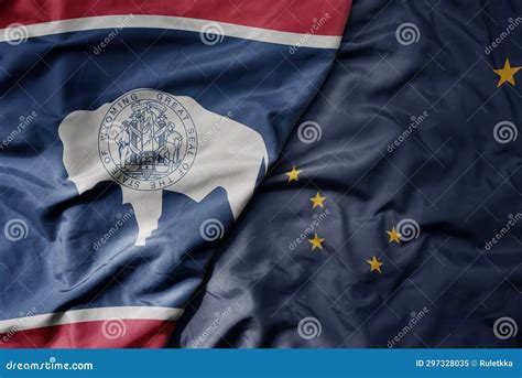 Big Waving Colorful National Flag Of Alaska State And Flag Of Wyoming