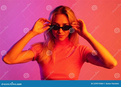 Cropped Image Of Young Stylish Girl Wearing Trendy Sunglasses Over Gradient Background In Neon