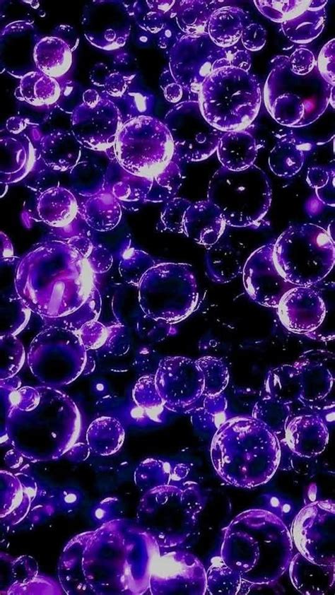 Purple Bubbles Floating In The Air On A Black Background