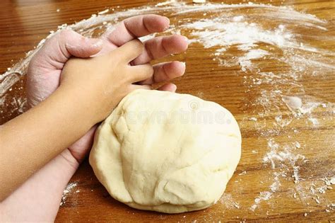 Mani Dell Adulto E Del Bambino Che Impastano La Pasta Di Pane Immagine