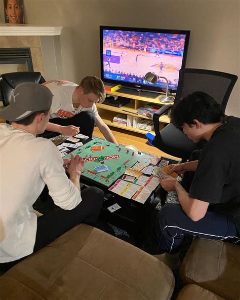 Four People Sitting Around A Table Playing A Board Game