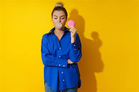 Heureuse Femme Soufflant Une Bulle Avec Du Chewing Gum Sur Fond Jaune