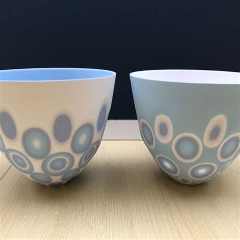 Two Blue And White Bowls Sitting On Top Of A Wooden Table Next To Each