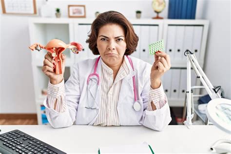 Middle Age Hispanic Doctor Woman Holding Anatomical Female Genital