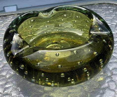 A Green Glass Bowl Sitting On Top Of A Table