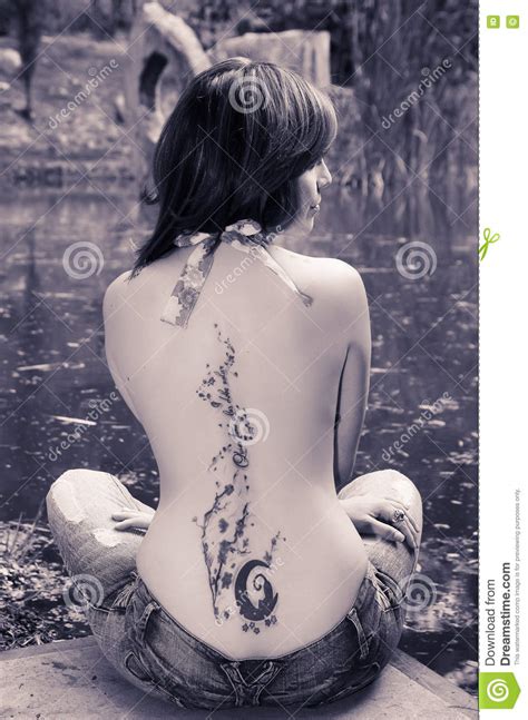 Brunette Topless Woman As Seen From Behind Sitting Down Next To Water