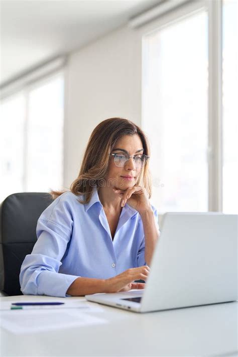 Busy Mature Business Woman Using Laptop Computer Working In Office