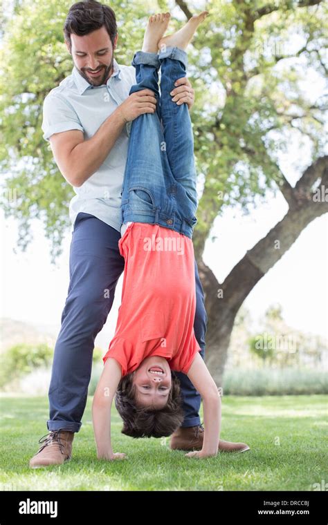 Father Holding Son Upside Down In Backyard Stock Photo Alamy