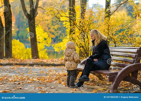 Une Belle Jeune Blonde Assise Sur Un Banc Dans Un Parc Dautomne Photo