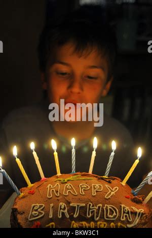 Un garçon de dix ans souffle les bougies sur son gâteau d anniversaire