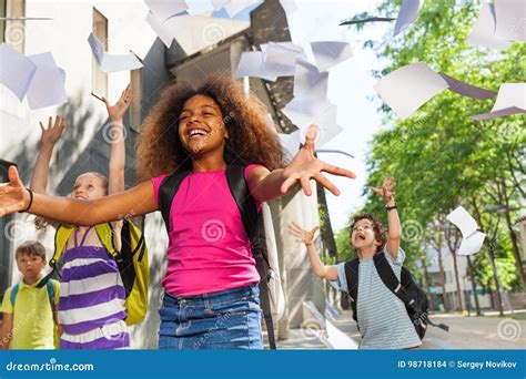 Girl Throw Papers In The Air For Friends To Catch Stock Photo Image