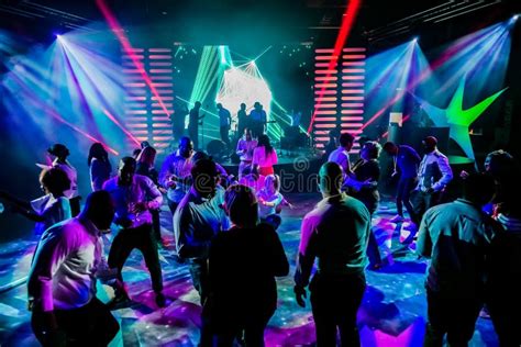 Group Of People Dancing On A Dance Floor In Dark Night Club Environment