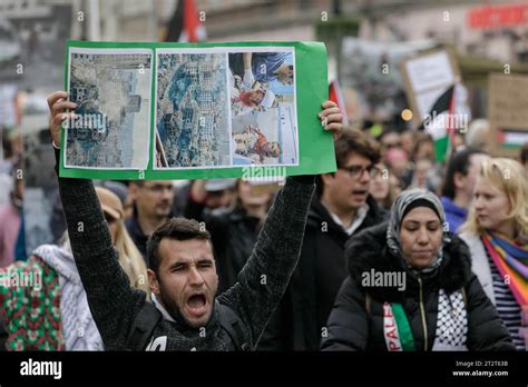 A Man Chants Slogans And Holds A Placard With Photographs During The