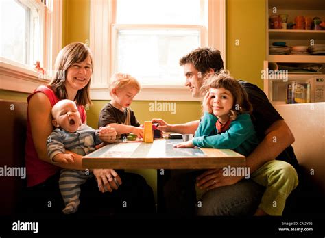 Familia sentada a la mesa de la cocina Fotografía de stock Alamy