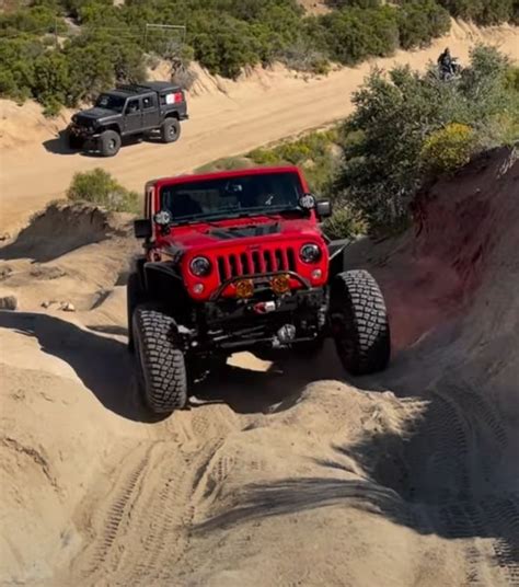 Two Jeeps Are Driving Through The Sand Dunes