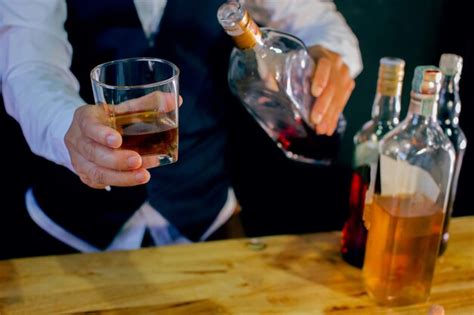 Premium Photo Midsection Of Bartender Holding Whiskey In Glass At Bar