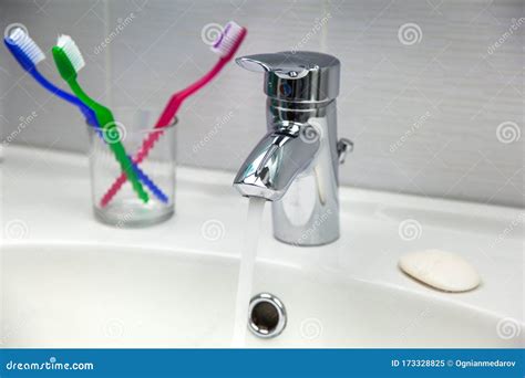 Water Tap Toothbrushes Soap And Running Water In A Sink Stock Image