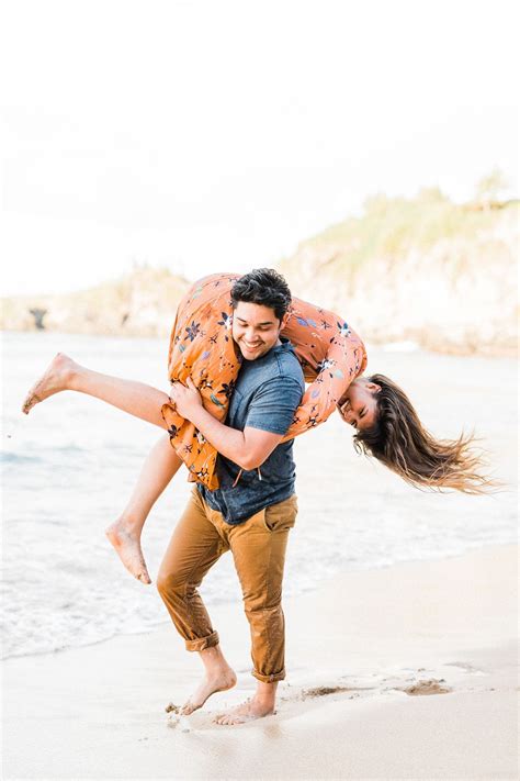 A Man Carrying A Woman On His Back At The Beach