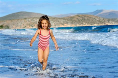 Menina Feliz Da Criança Que Funciona Na Praia Foto de Stock Imagem de