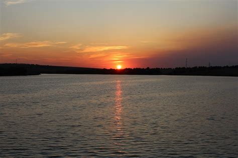 Una Puesta De Sol Sobre Un Cuerpo De Agua Foto Premium