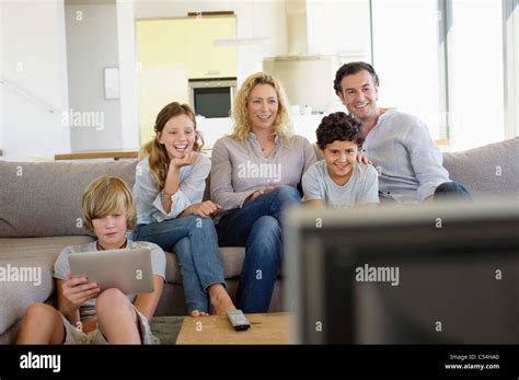 Family watching TV together at home Stock Photo - Alamy