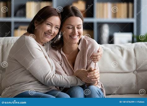 Smiling Mature Mother And Grown Up Daughter Hugging Expressing Love