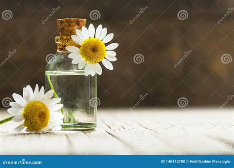 Aceite Esencial En La Botella De Cristal Con Las Flores Frescas De La