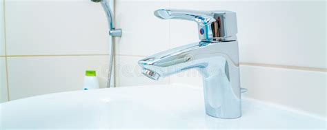 Chromed Metal Faucet For Hot And Cold Water Cup With Sad Face For Toothbrushes In A Modern