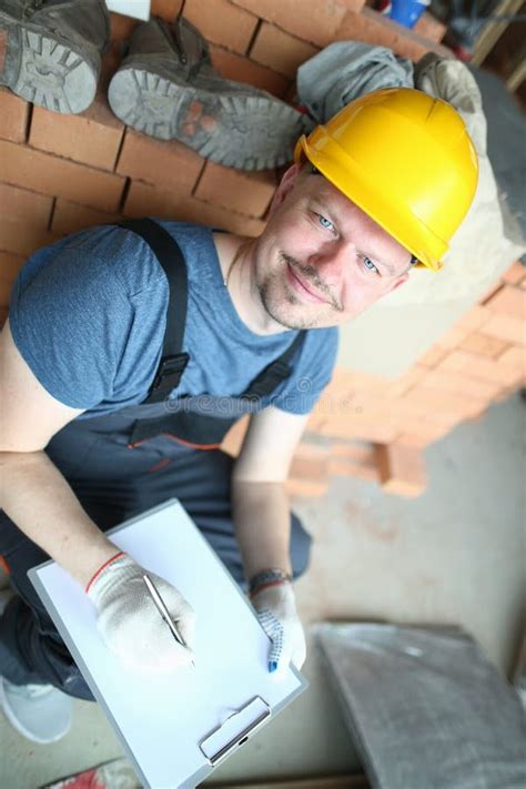 Construtor Masculino Em Posses Amarelas Do Capacete De Seguran A Foto