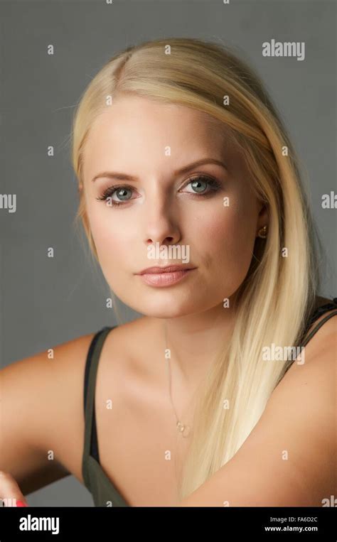Une jeune fille blonde se trouve dans le studio elle porte un top vert olive Elle ressemble à