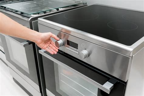 Woman`s Hands Adjusting Heat Button On Oven Machine Stock Photo Image