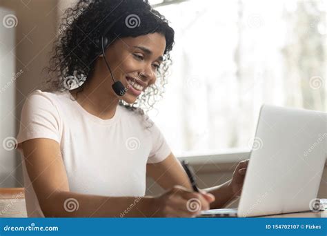 Smiling African Woman Wearing Headphones Listening Audio Course Using