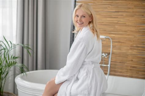 Premium Photo Spa Day Blonde Pretty Woman In A White Bath Robe Getting The Bath Ready