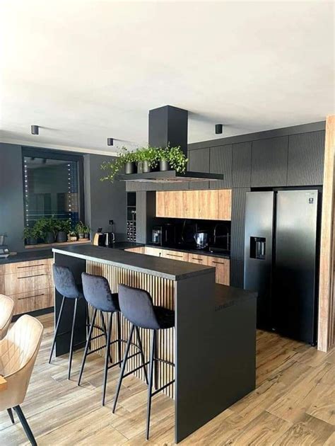 A Kitchen With An Island And Bar Stools Next To The Counter Top In