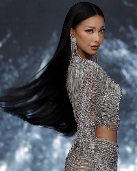 A Woman With Long Black Hair Walking Down The Runway Wearing A Silver