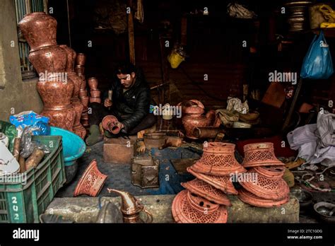 Un Kashmiri Coppersmith Travaille Sur Un Ustensile En Cuivre Dans Un