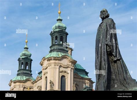 Jan Hus Monument In Old Town Square In Prague With St Nicholas Church