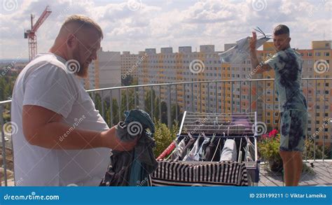 A Gay Couple Hangs Up The Laundry On The Balcony To Dry Stock Image Image Of Bisexual Male