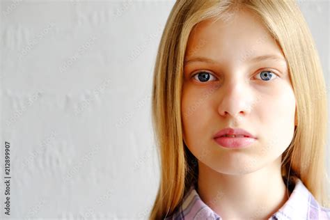 Headshot Of Beautiful Teenage Girl With Blonde Straight Hair Blue Eyes Looking At The Camera