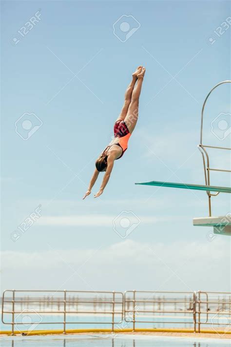 Woman Diving Into The Pool From Spring Board Female Diver Diving