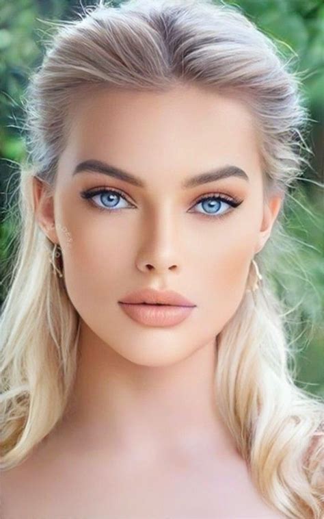 A Woman With Long Blonde Hair And Blue Eyes Is Posing For A Photo In