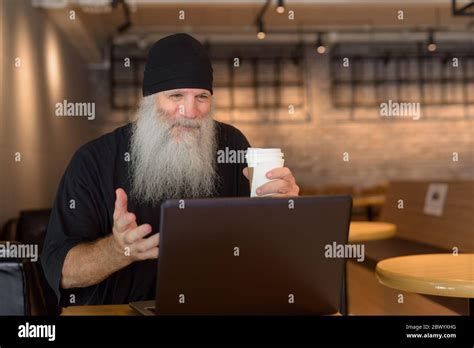 Mature Handsome Bearded Hipster Man Video Calling At The Coffee Shop